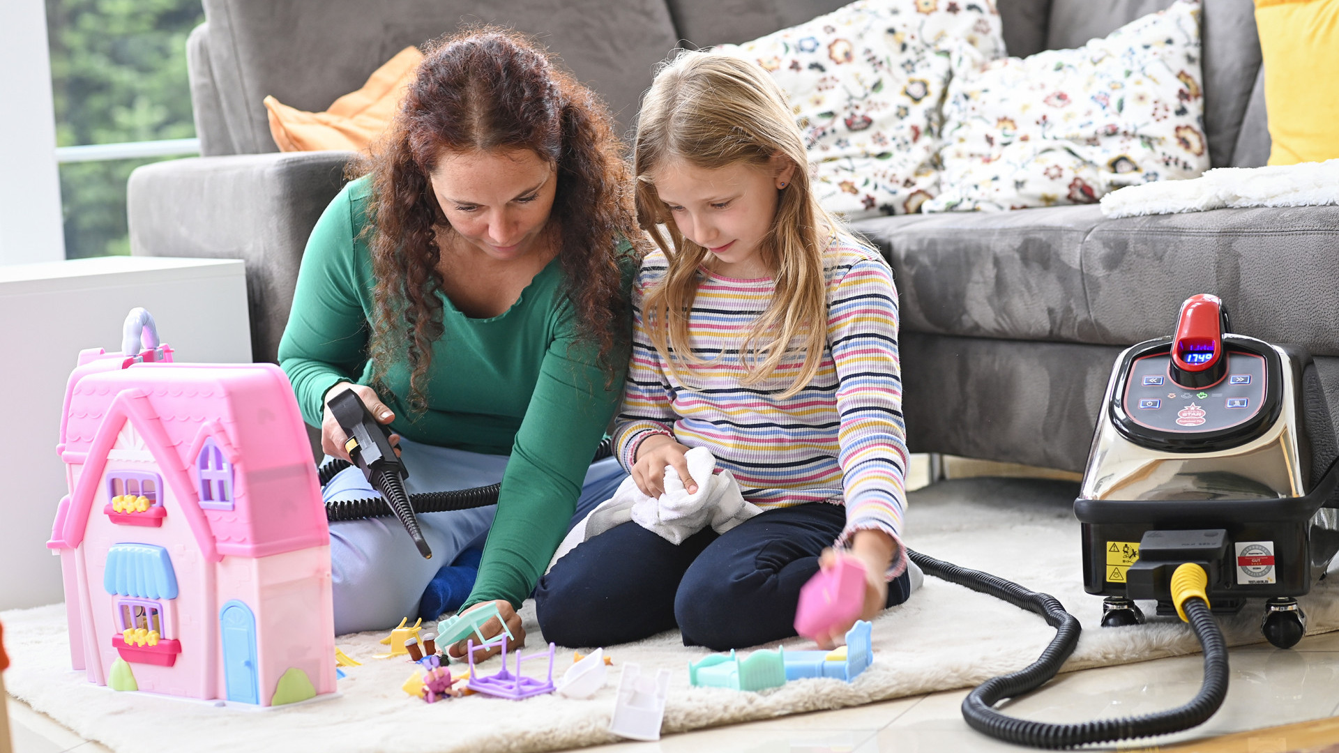 A girl plays with a doll's house and her mother playfully cleans the little figures with her using only dry steam from Thermostar