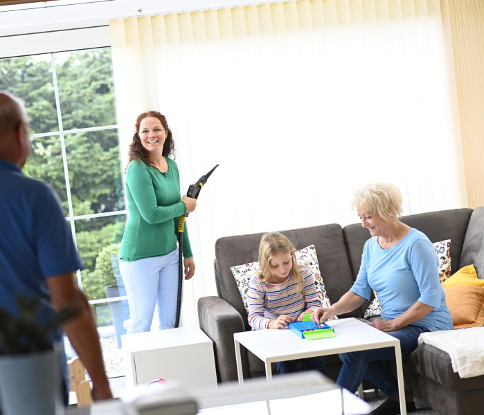 Happy family in the conservatory while mum cleans the louvre curtain with Thermostar dry steam